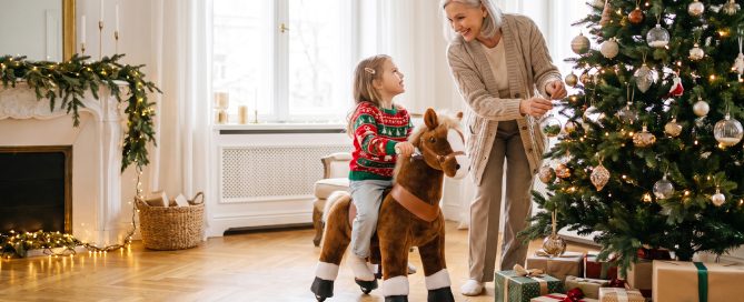 grandmother watching her granddaughter ride a ride-on horse toy